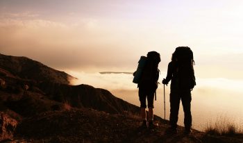 Hikers on a hillside overlooking a beautiful landscape.
