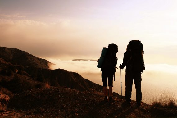 Hikers on a hillside overlooking a beautiful landscape.
