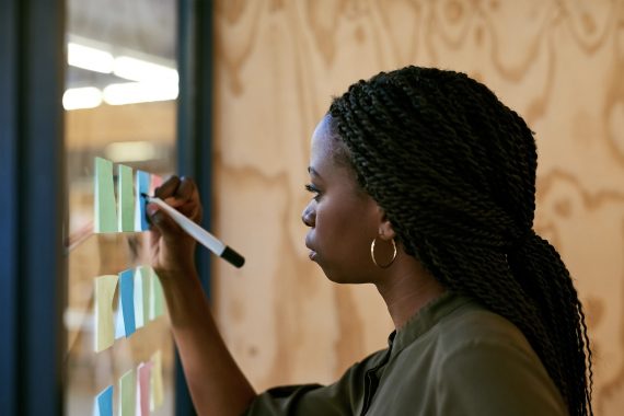Woman strategizing with post it notes.