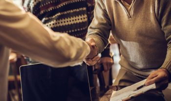 Handshake between business man and older couple