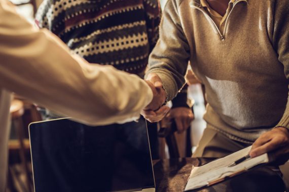Handshake between business man and older couple