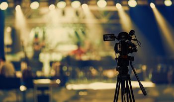 Video camera on tripod recording stage