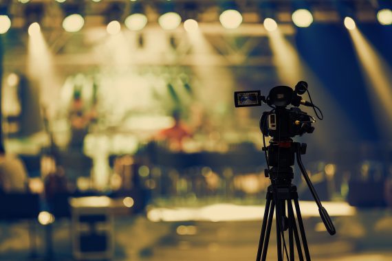 Video camera on tripod recording stage