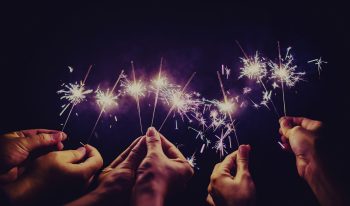 Many hands holding hand-held fireworks