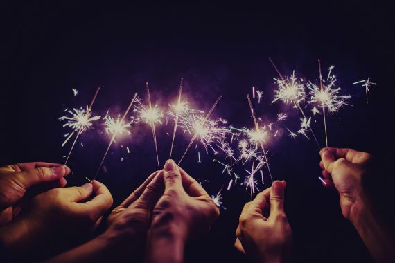 Many hands holding hand-held fireworks
